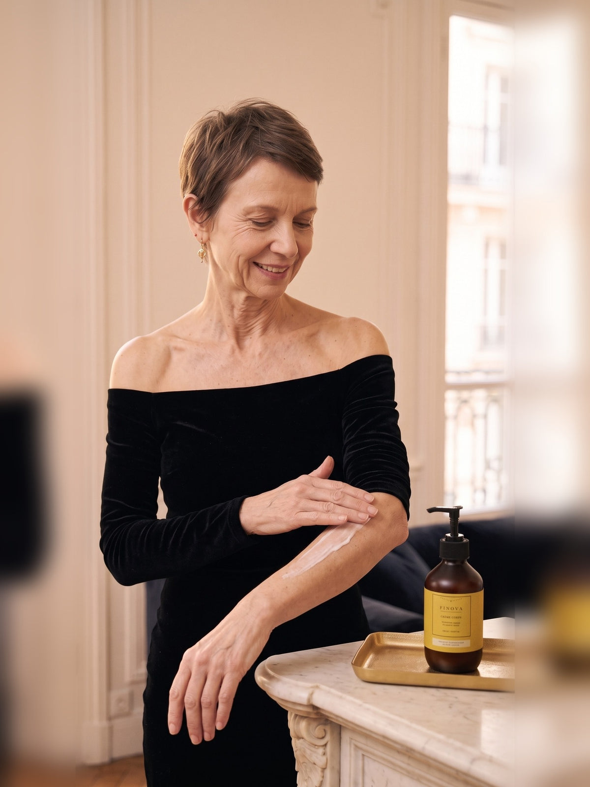 Femme qui applique la crème corps FINOVA sur son bras